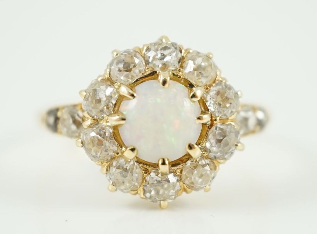 An early 20th century gold, white opal and diamond set circular cluster ring